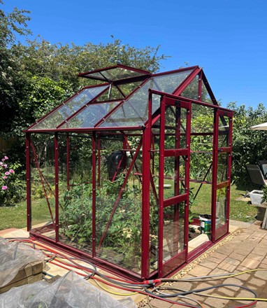 <strong>STRATA:</strong> A 6’3 (1900mm) wide model in lengths from 4’5 (1351mm) onwards. It has eaves of 5’2 (1585mm) and double doors which provide an opening of 6’3 x 2’9 (1910mm x 840mm) ensuring a good working space. Pictured is an Elite Strata 6ft 3in x 6ft 4in “Berry” colour finish, with staging, shelf, auto opener and rain kit.