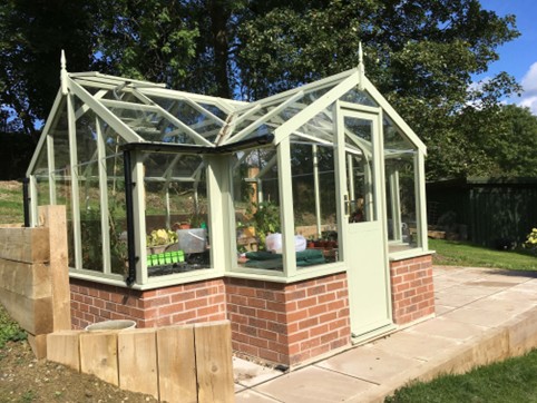 <strong>MALLARD:</strong> A T-shaped 8ft 9in deep (2660mm) model with porch and toughened safety glass. Locking hinged door. Various lengths available from 11'5 (3490mm) . Various finishes & options. Pictured is 8ft 9in x 11ft 5in Mallard painted Vert de Terre on a dwarf wall.